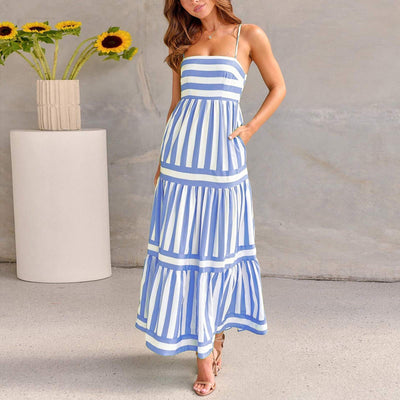 Femme portant une robe longue à bretelles rayée bleue et blanche style plage élégante et fluide