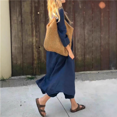 Femme en ensemble 2 pièces bleu marine avec sac en paille, style décontracté et élégant.