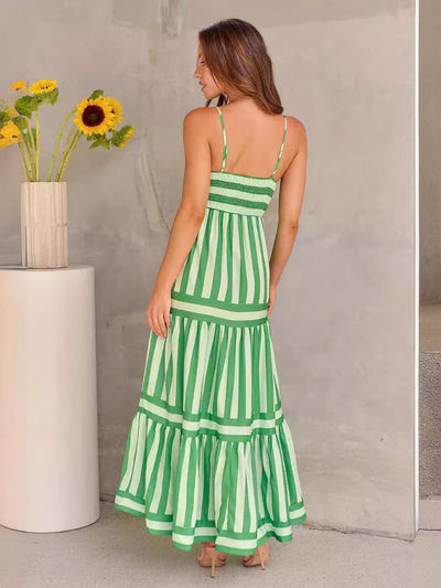 Femme portant une robe longue à bretelles rayée verte style plage fluide et élégante vue de dos