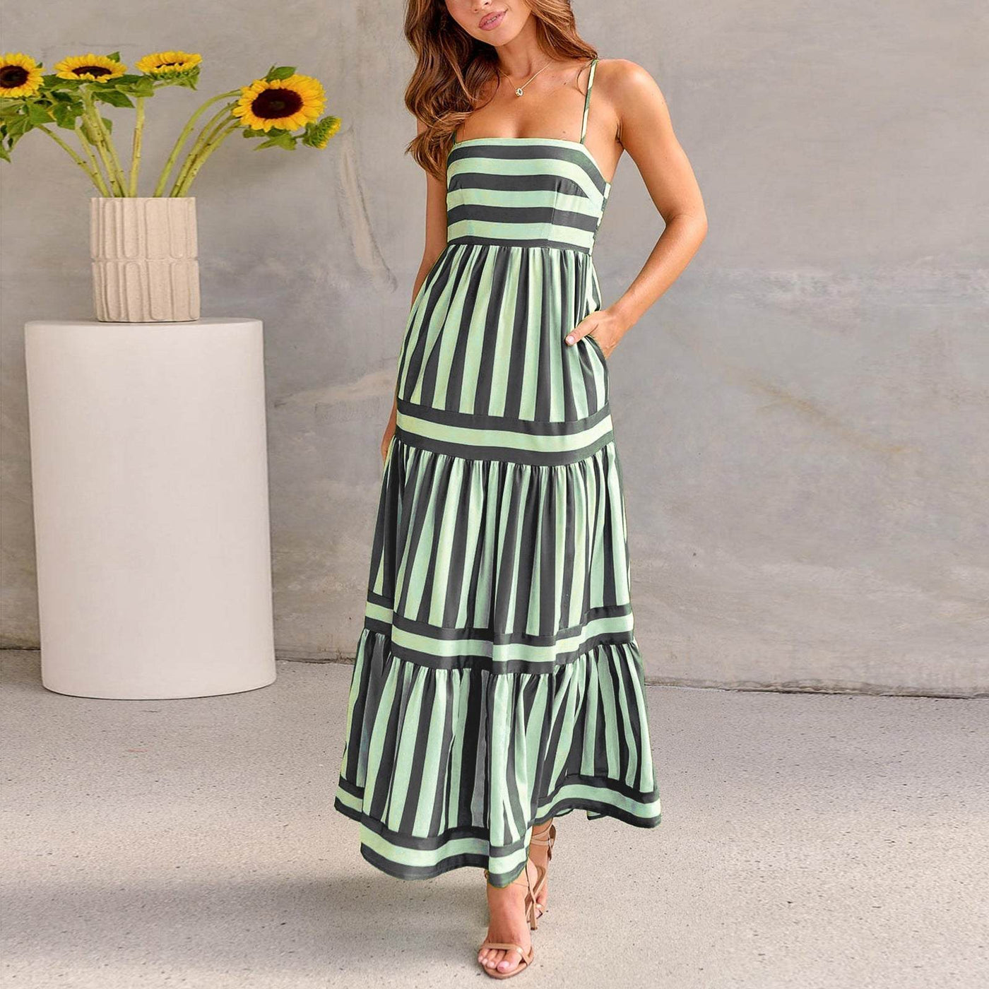 Femme portant une robe longue à bretelles rayée, style plage, coupe fluide et décontractée.
