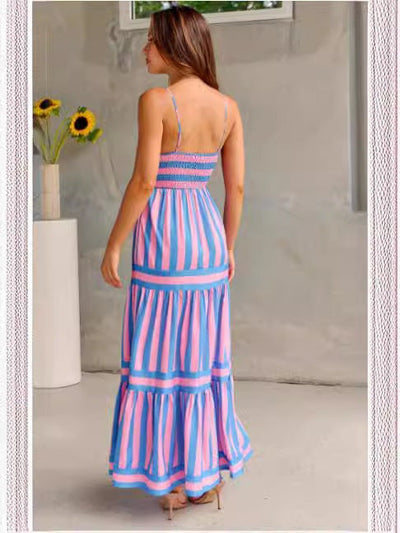 Femme portant une robe longue à bretelles rayée rose et bleu style plage vue de dos.